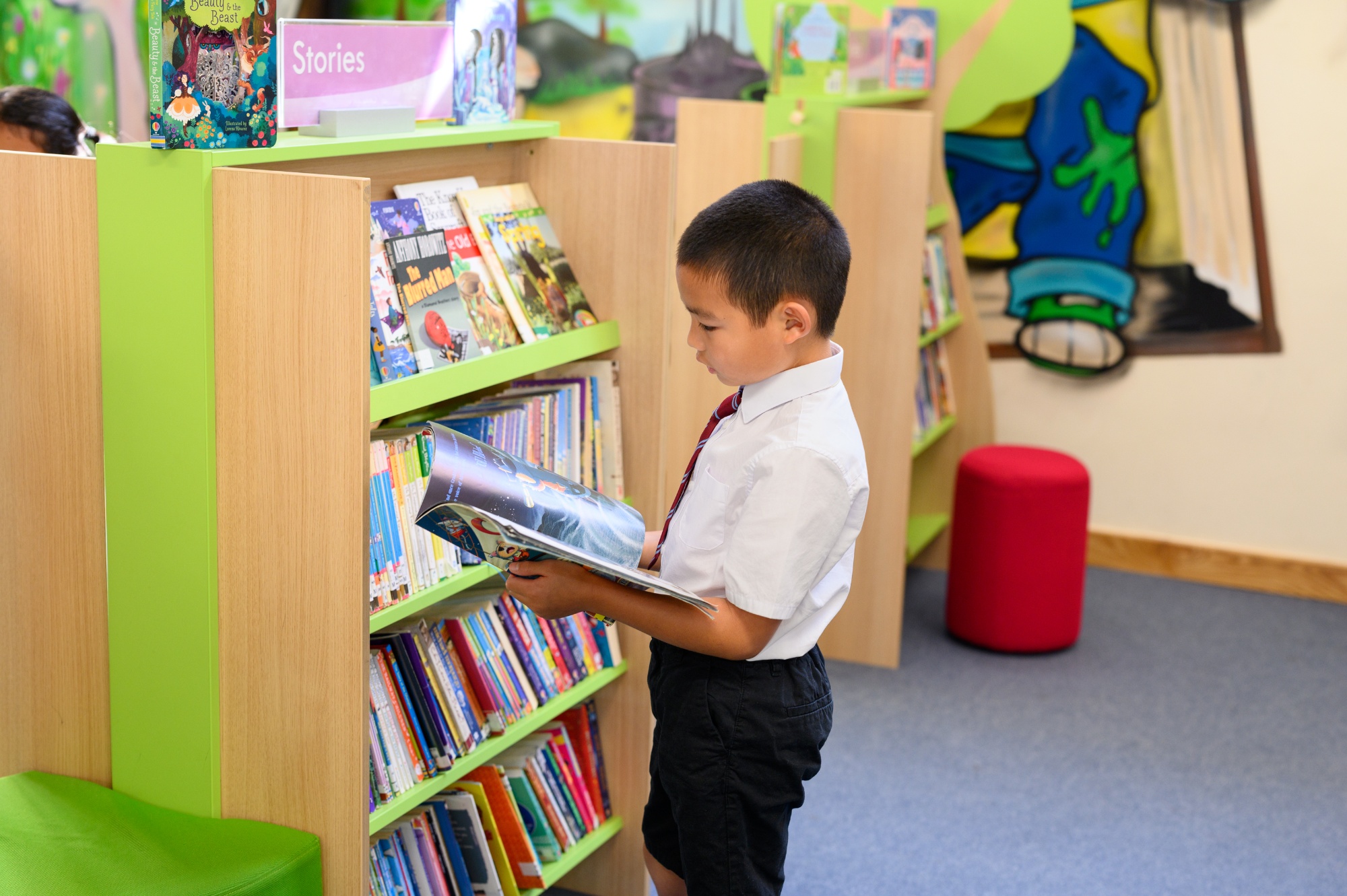 child selecting a book in the library
